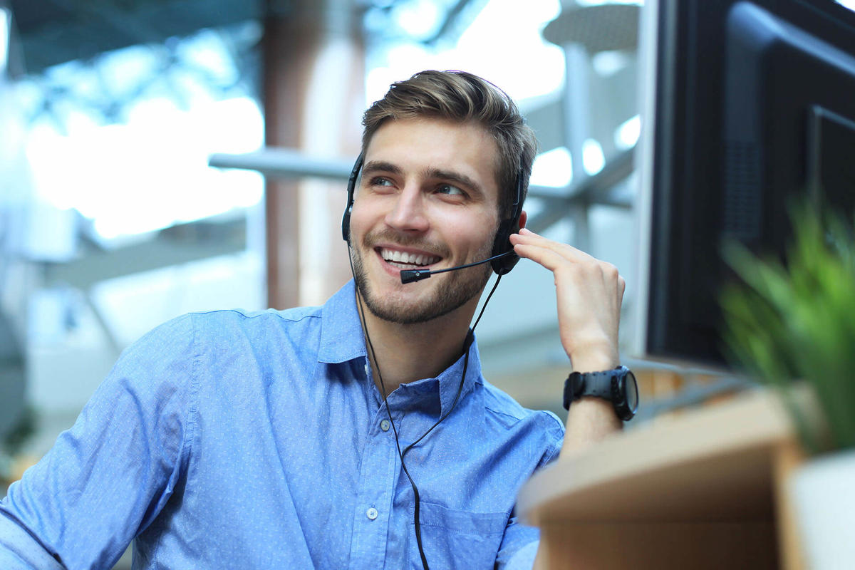 Man with headset at a helpdesk talking on the phone