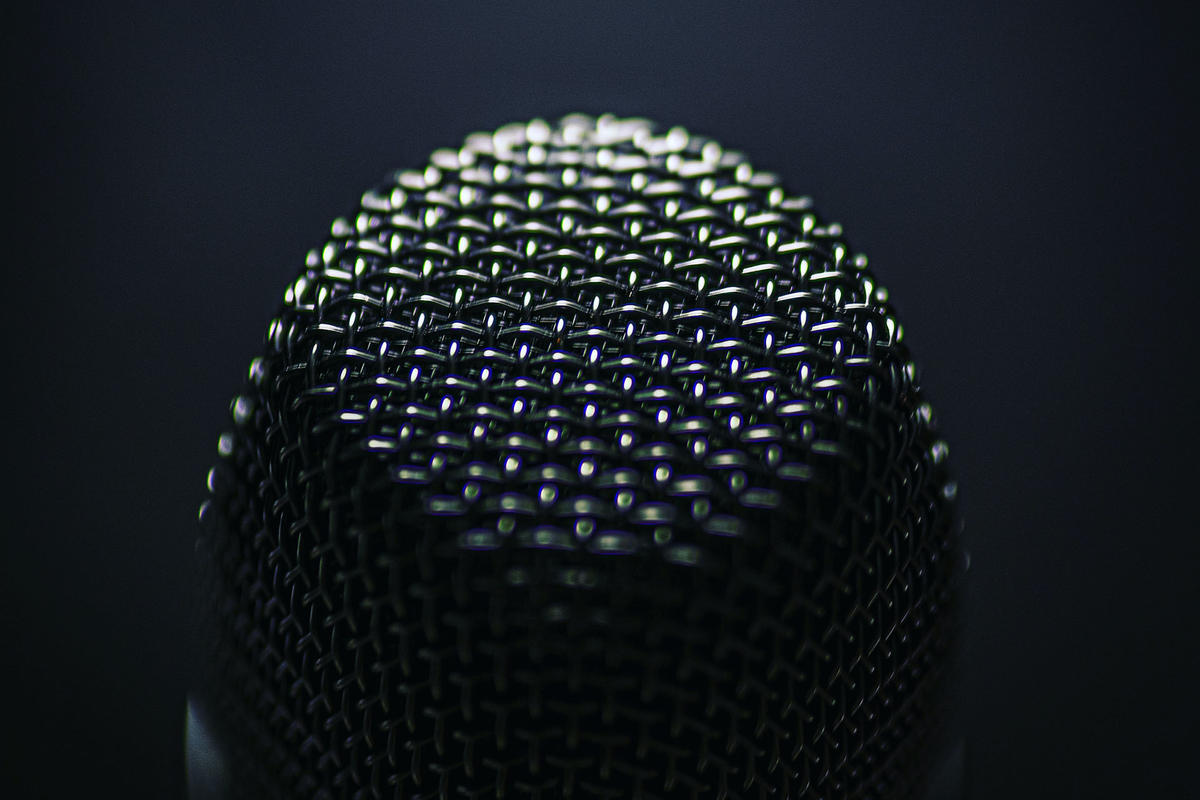 Closeup of microphone in a black background